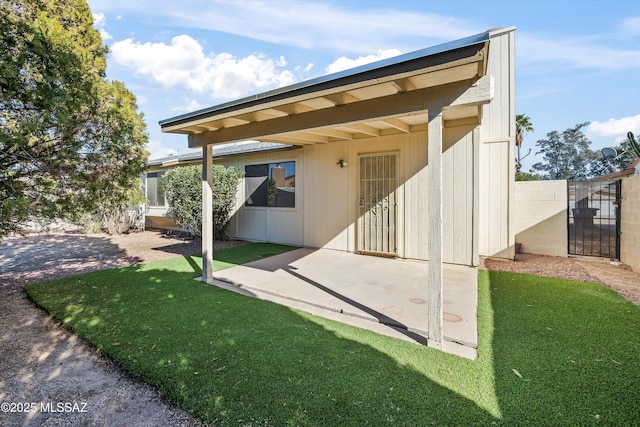 back of property featuring a patio area and a lawn