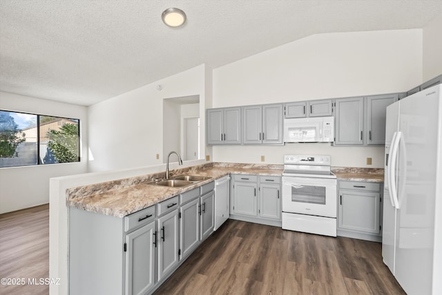 kitchen featuring kitchen peninsula, vaulted ceiling, sink, and white appliances