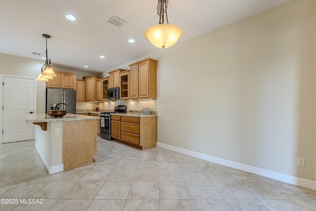 kitchen featuring appliances with stainless steel finishes, decorative light fixtures, an island with sink, and a breakfast bar area