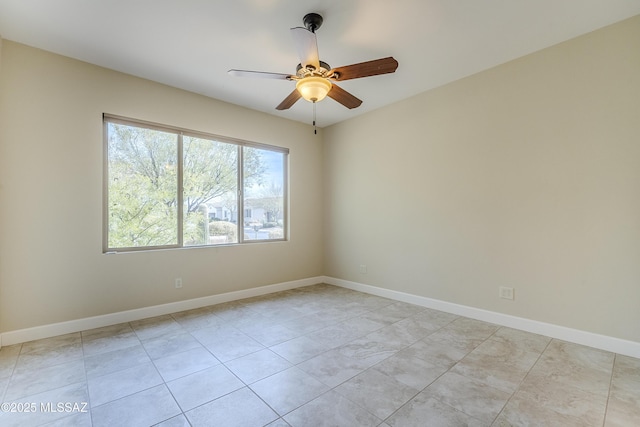 tiled spare room featuring ceiling fan