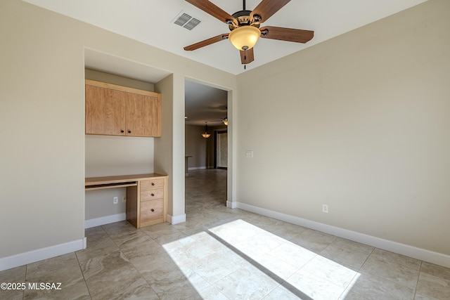 unfurnished bedroom featuring built in desk and ceiling fan