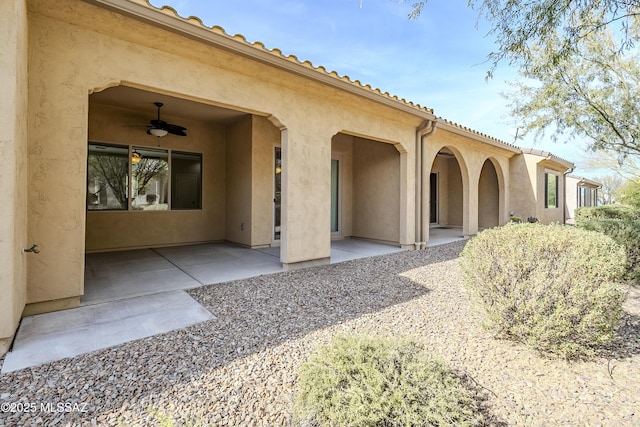 property entrance with a patio and ceiling fan