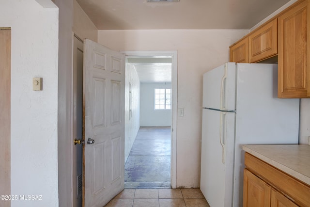 kitchen featuring light tile patterned floors and white refrigerator