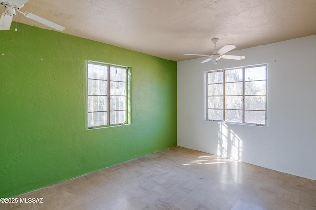 spare room featuring a textured ceiling, plenty of natural light, and ceiling fan