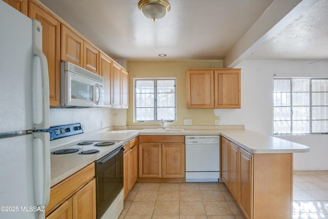 kitchen featuring sink, kitchen peninsula, white appliances, light brown cabinetry, and light tile patterned flooring