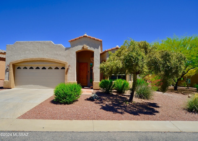 mediterranean / spanish home featuring a garage