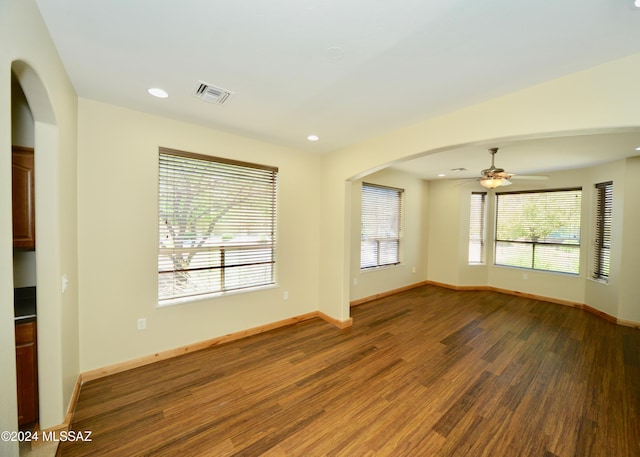 empty room with dark wood-type flooring and ceiling fan