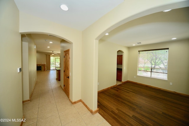 hallway with light tile patterned flooring and a healthy amount of sunlight