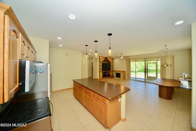 kitchen with light tile patterned floors, stainless steel appliances, ceiling fan, and decorative light fixtures