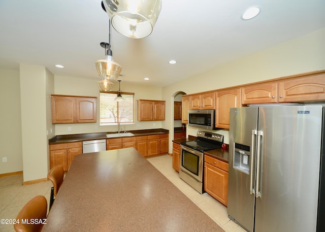 kitchen with pendant lighting, stainless steel appliances, and sink