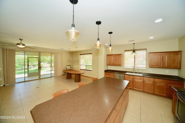 kitchen with sink, dishwasher, hanging light fixtures, and plenty of natural light