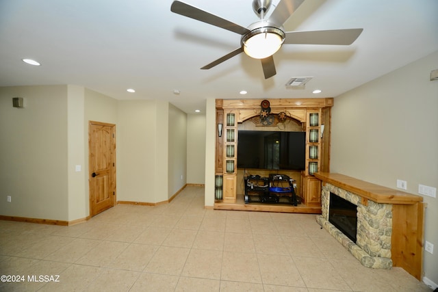 unfurnished living room featuring a fireplace, ceiling fan, and light tile patterned flooring