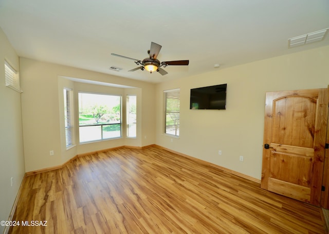 unfurnished room with light wood-type flooring and ceiling fan