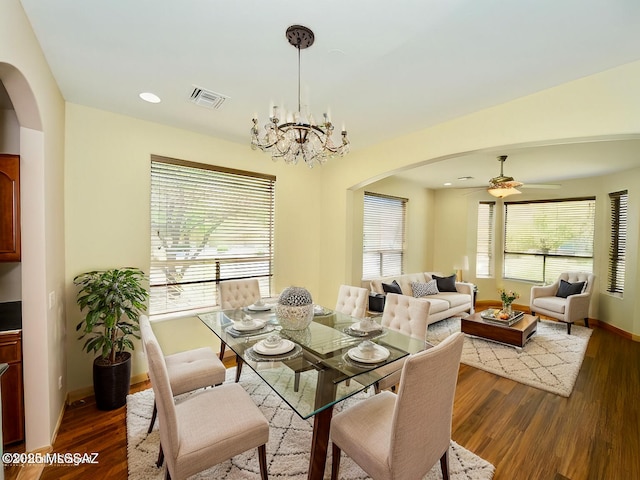 dining room featuring dark hardwood / wood-style flooring and ceiling fan with notable chandelier