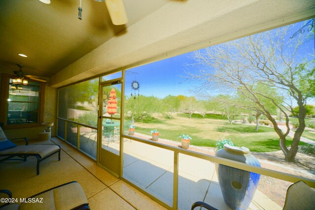 unfurnished sunroom with ceiling fan