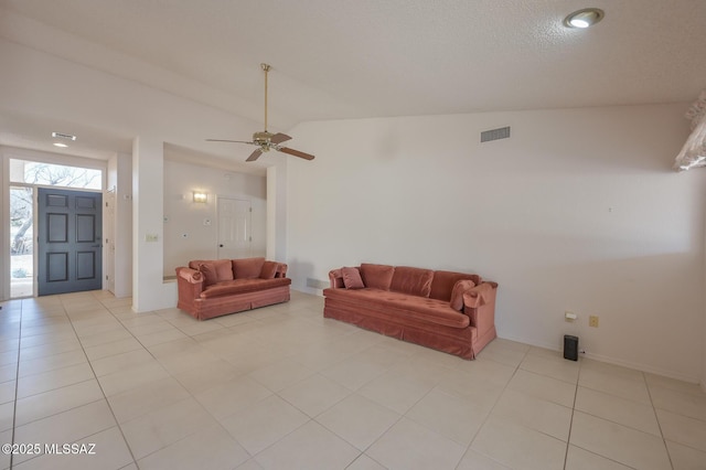 living room with lofted ceiling, light tile patterned floors, a textured ceiling, and ceiling fan