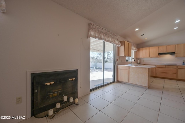 kitchen with light tile patterned flooring, light brown cabinetry, sink, vaulted ceiling, and black electric cooktop