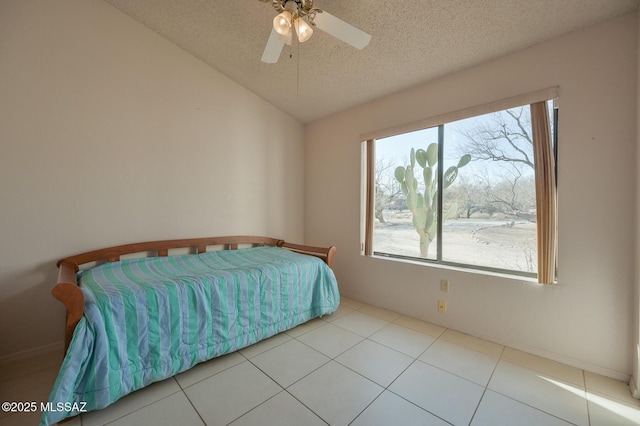 bedroom featuring ceiling fan, vaulted ceiling, a textured ceiling, and light tile patterned flooring