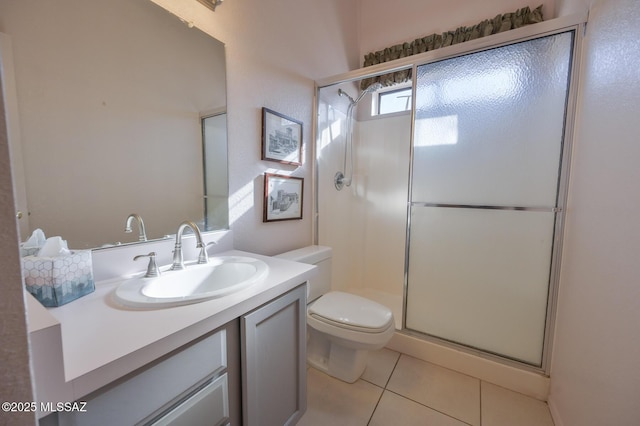 bathroom featuring tile patterned flooring, vanity, a shower with shower door, and toilet