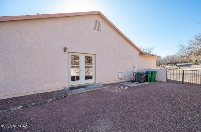 rear view of property featuring french doors and central air condition unit