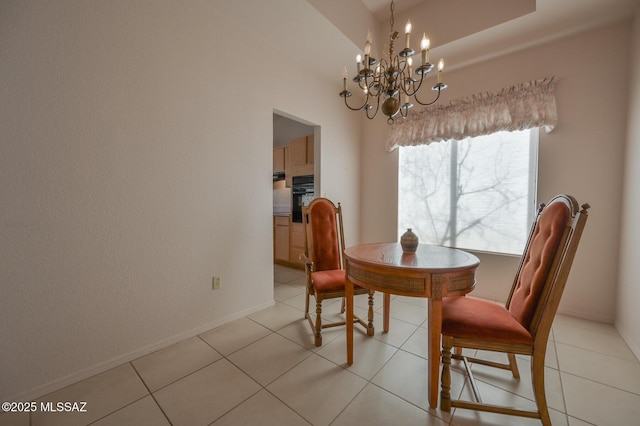 tiled dining room with a tray ceiling and a notable chandelier