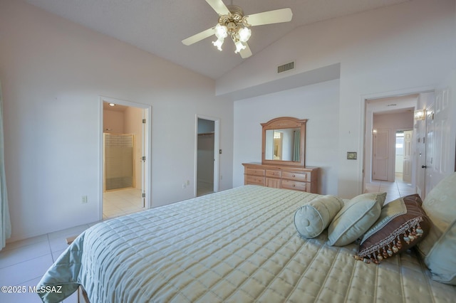 bedroom with light tile patterned floors, ceiling fan, connected bathroom, a spacious closet, and vaulted ceiling