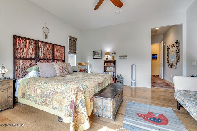 bedroom with ceiling fan, light wood-type flooring, visible vents, and baseboards