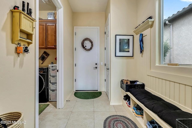 mudroom with light tile patterned floors, washer / clothes dryer, and baseboards