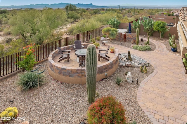 view of patio / terrace with a fenced backyard, a fire pit, and a mountain view