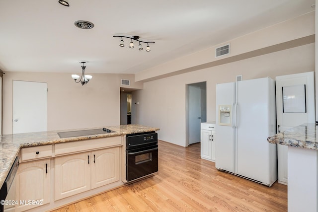 kitchen with light stone counters, black appliances, light hardwood / wood-style flooring, a chandelier, and lofted ceiling