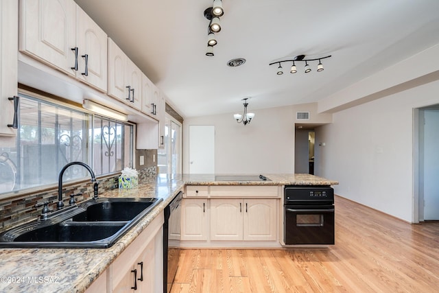 kitchen with light wood-type flooring, tasteful backsplash, black appliances, sink, and lofted ceiling