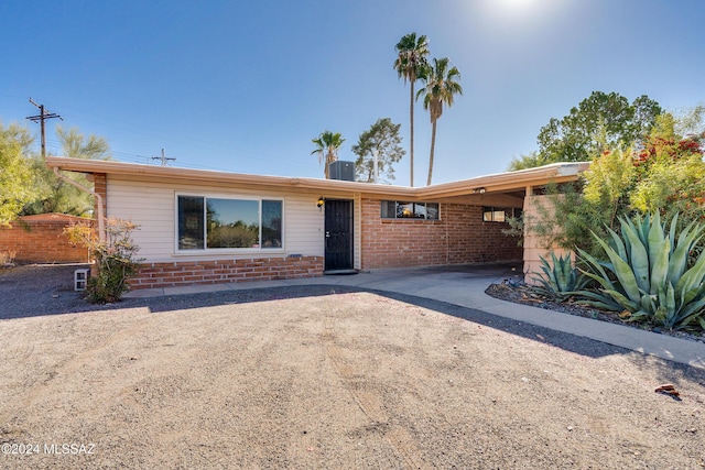 single story home with central air condition unit and a carport