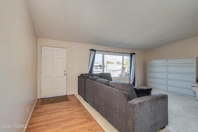 living room with light hardwood / wood-style floors and lofted ceiling