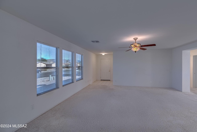 carpeted spare room with ceiling fan