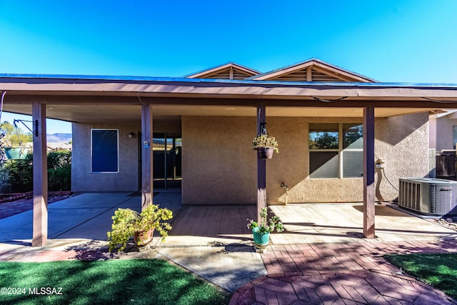 rear view of property featuring cooling unit and a patio area