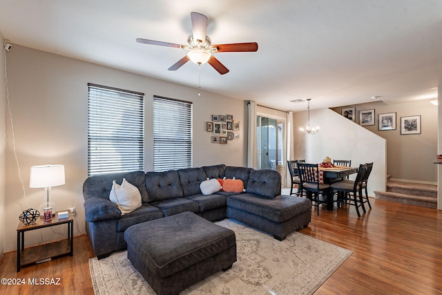 living room with hardwood / wood-style floors and ceiling fan with notable chandelier