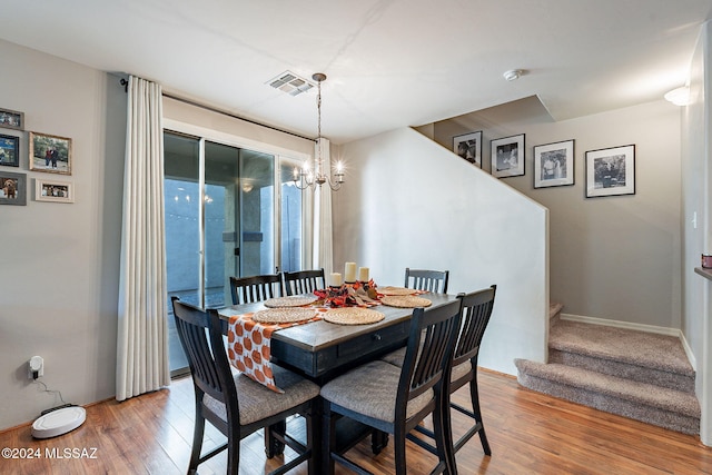 dining space featuring an inviting chandelier and hardwood / wood-style flooring