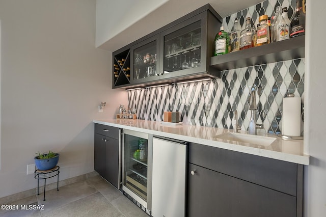 bar with tasteful backsplash, sink, stainless steel fridge, and beverage cooler