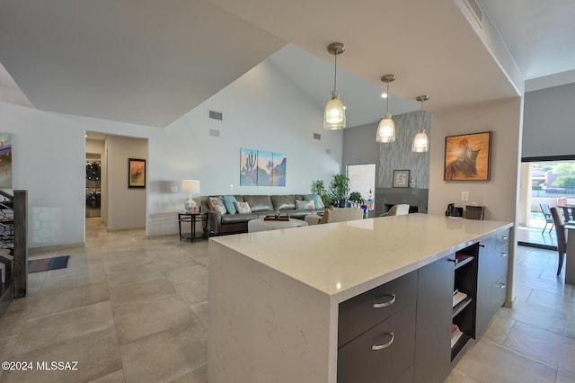 kitchen with a kitchen island, high vaulted ceiling, washer / clothes dryer, and decorative light fixtures