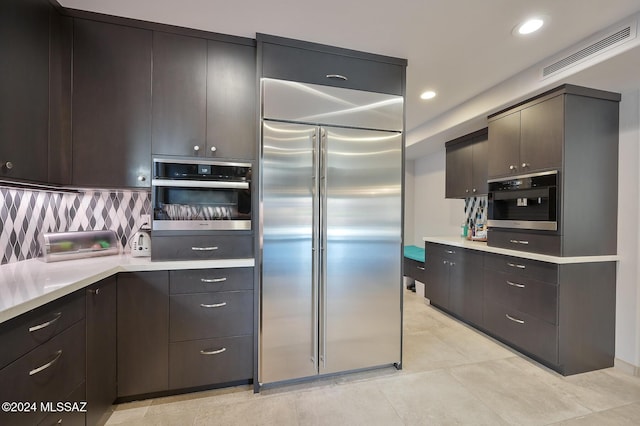 kitchen with appliances with stainless steel finishes, backsplash, and dark brown cabinetry