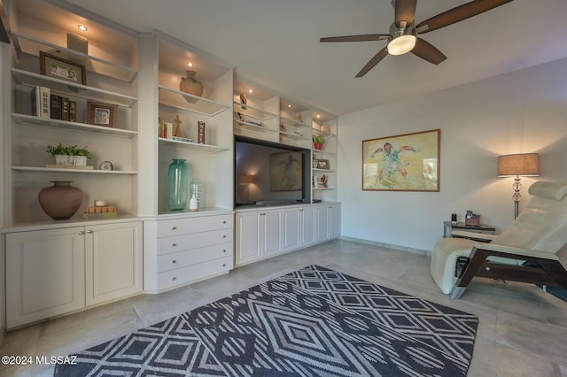 living room with ceiling fan and built in shelves