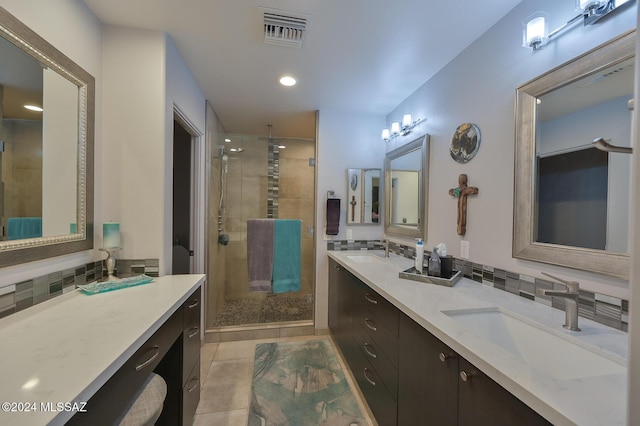 bathroom with an enclosed shower, vanity, tasteful backsplash, and tile patterned flooring