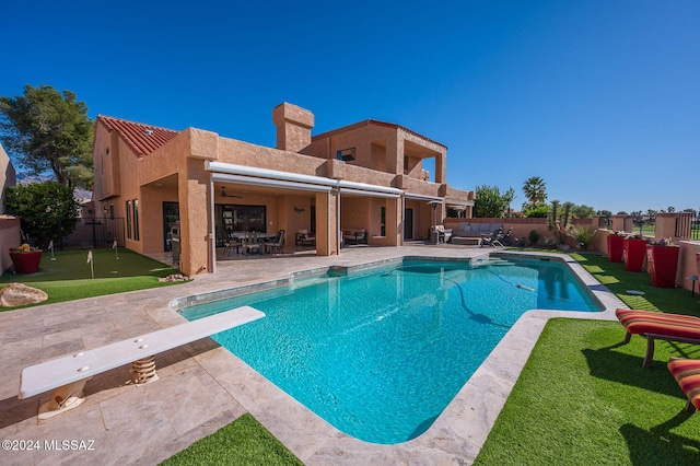 view of pool with a diving board and a patio