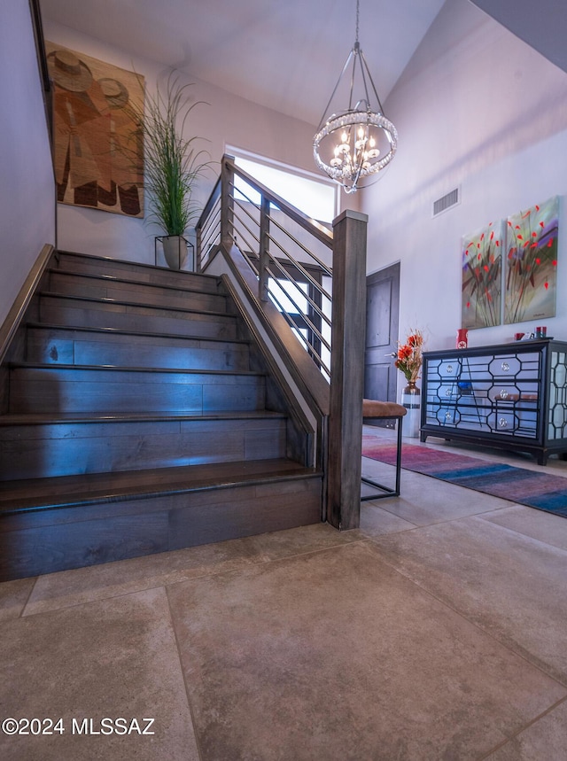 stairway featuring high vaulted ceiling and a notable chandelier