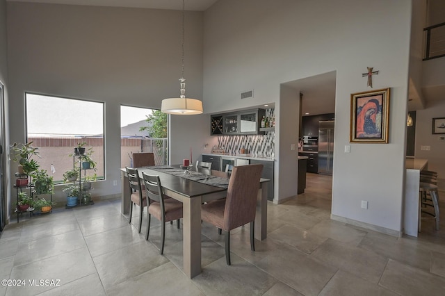 dining room with a towering ceiling and concrete flooring