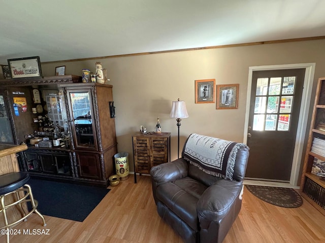 sitting room with hardwood / wood-style floors and crown molding