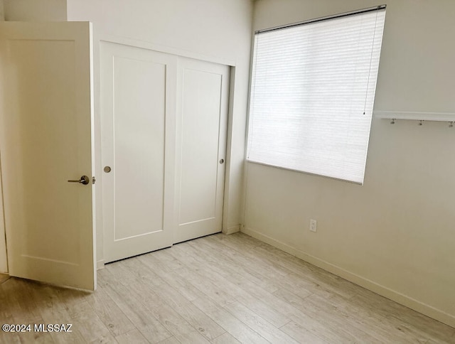 unfurnished bedroom with light hardwood / wood-style floors and a closet