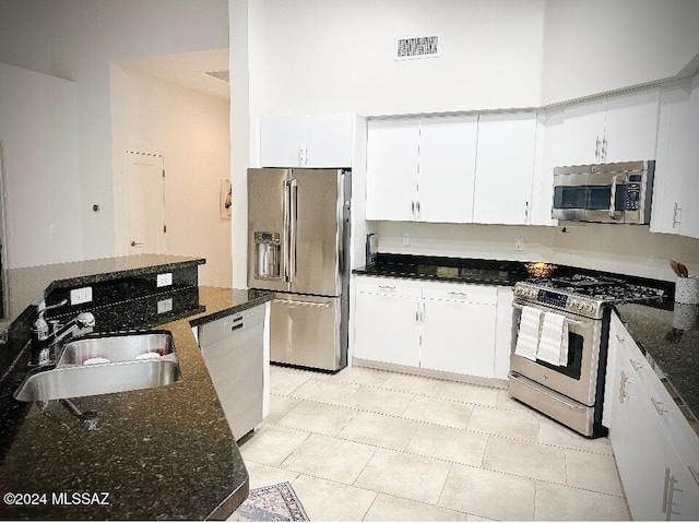 kitchen featuring white cabinets, dark stone countertops, sink, and appliances with stainless steel finishes