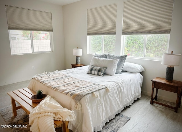 bedroom featuring multiple windows and light hardwood / wood-style flooring