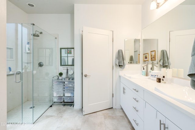 bathroom featuring tile patterned floors, a shower with door, and vanity